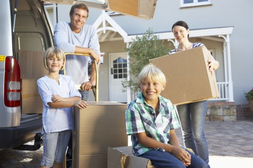 Professional movers carrying household items from a Watford property