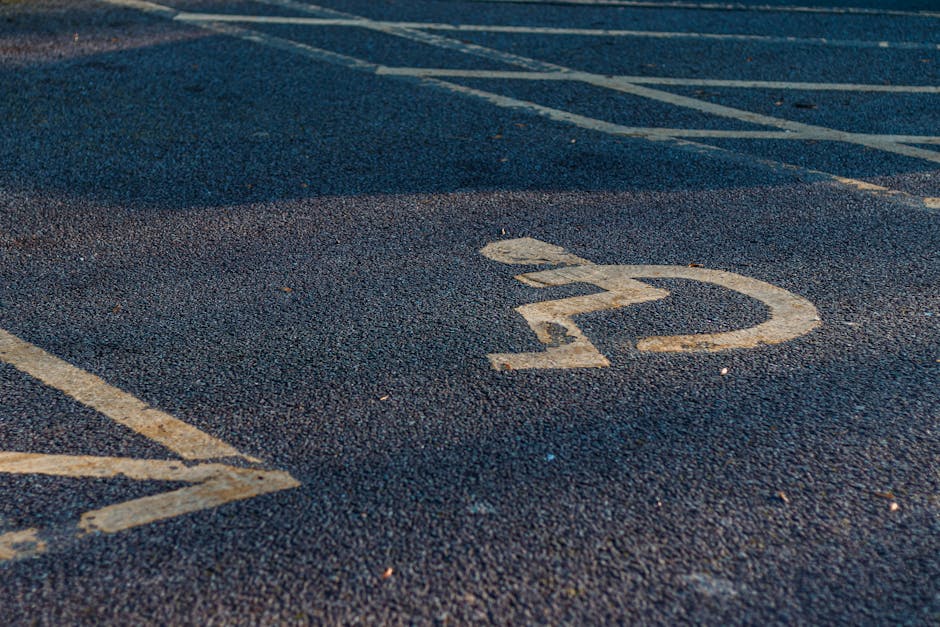 Close-up of an empty parking space with a white painted number '22' on dark asphalt. Visible parking lines run adjacent to the space, and the surface shows minor wear and small debris. The scene appears to be outdoors, within a parking lot that may be used during home relocation or furniture transport activities, as managed by Man with Van Watford for their house removals services. The image emphasizes parking organization and access considerations relevant to moving operations near Cassiobury Park in Watford, with natural lighting highlighting the textured asphalt and painted markings. This setting is typical of areas used for loading and unloading furniture and packing materials during a house move.